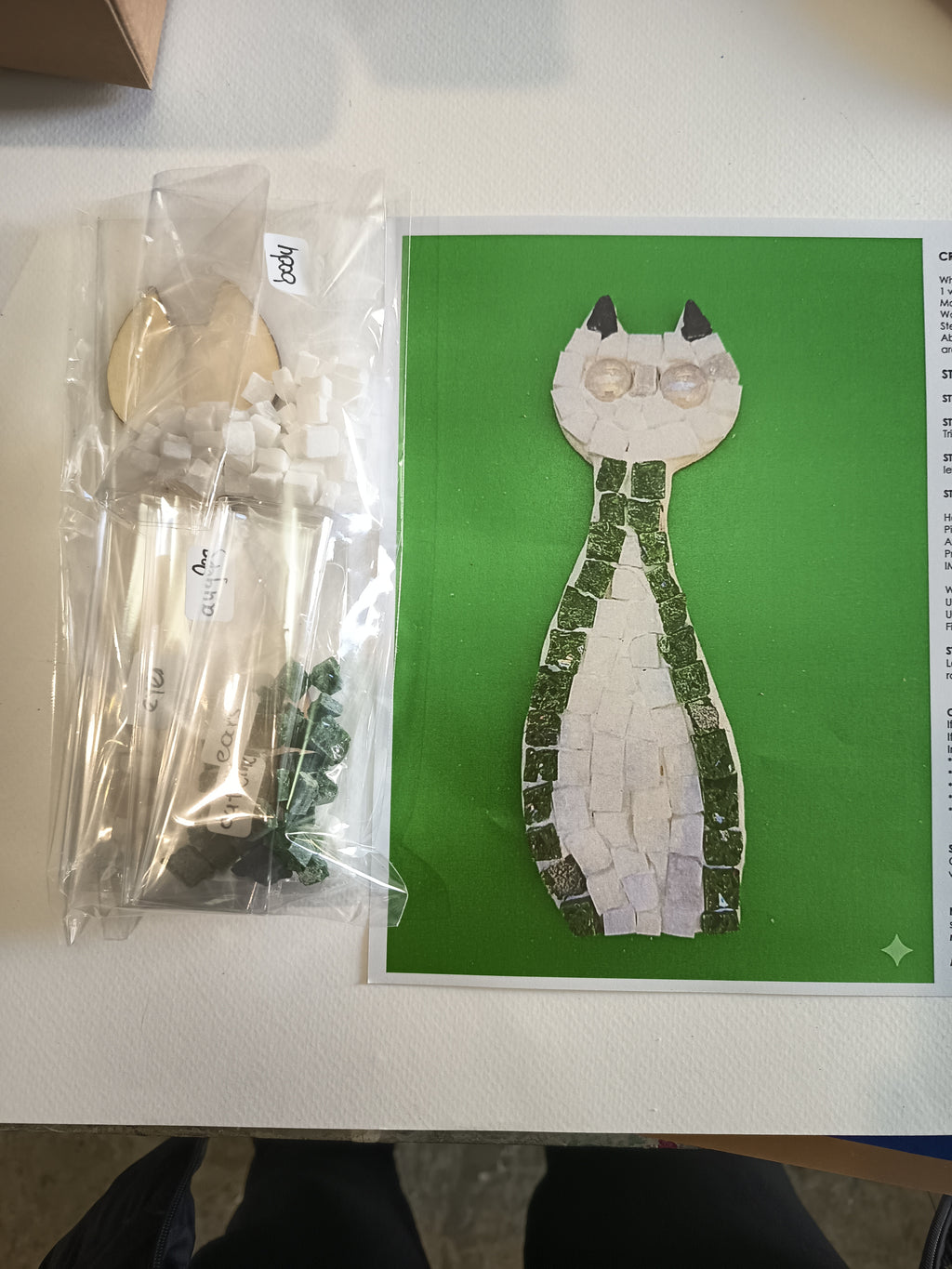 DIY mosaic cat kit contents - wooden cat base, hand-cut Greek marble tiles (square and triangle), border in your chosen color (red, blue, green, light green or black), eye pieces, wall hook and glue