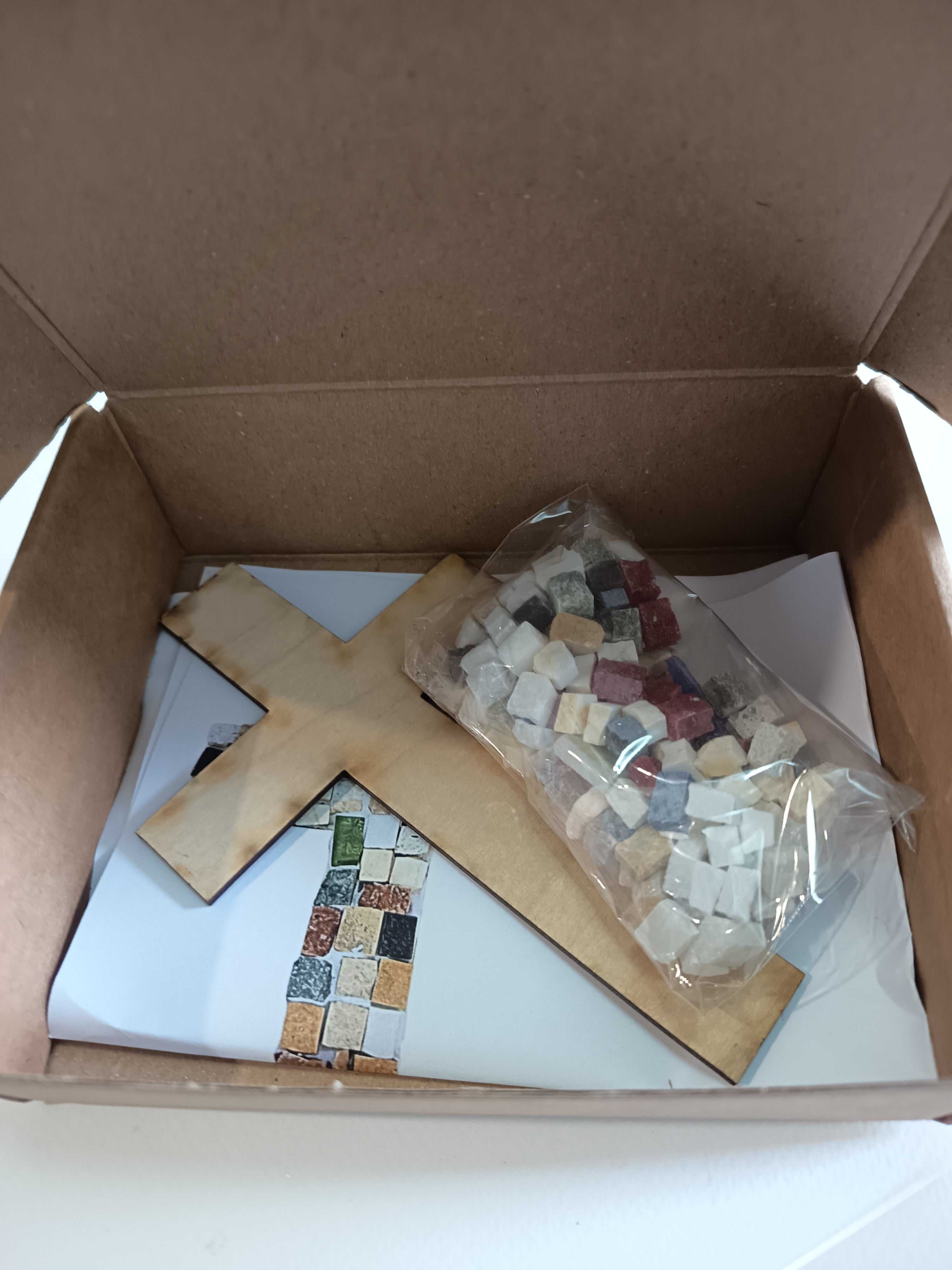 DIY mosaic cross kit - here you can see exactly what you will receive: wooden cross base, hand-cut marble tiles, center tile in your chosen color, glue, wall hook and printed instructions
