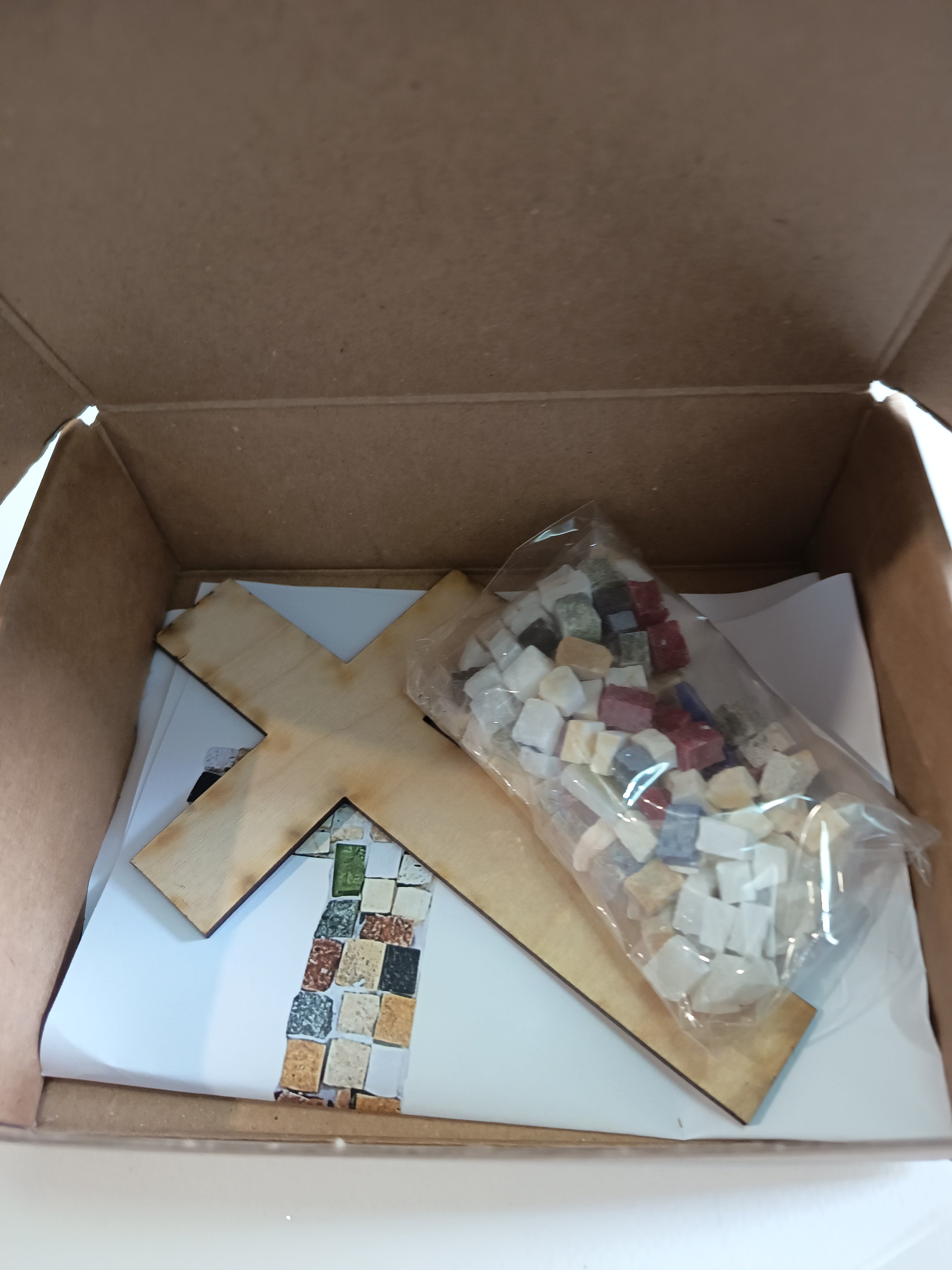 DIY mosaic cross kit - here you can see exactly what you will receive: wooden cross base, hand-cut marble tiles, center tile in your chosen color, glue, wall hook and printed instructions