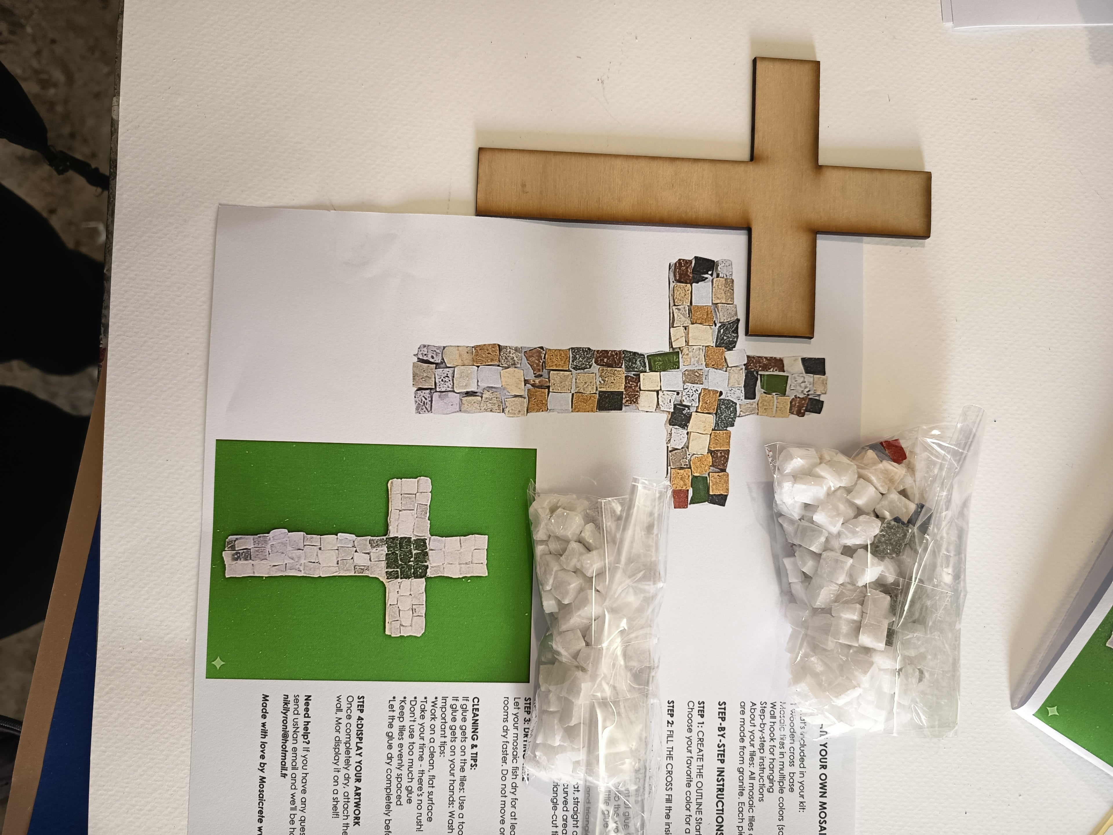 DIY mosaic cross kit - here you can see exactly what you will receive: wooden cross base, hand-cut marble tiles, center tile in your chosen color, glue, wall hook and printed instructions