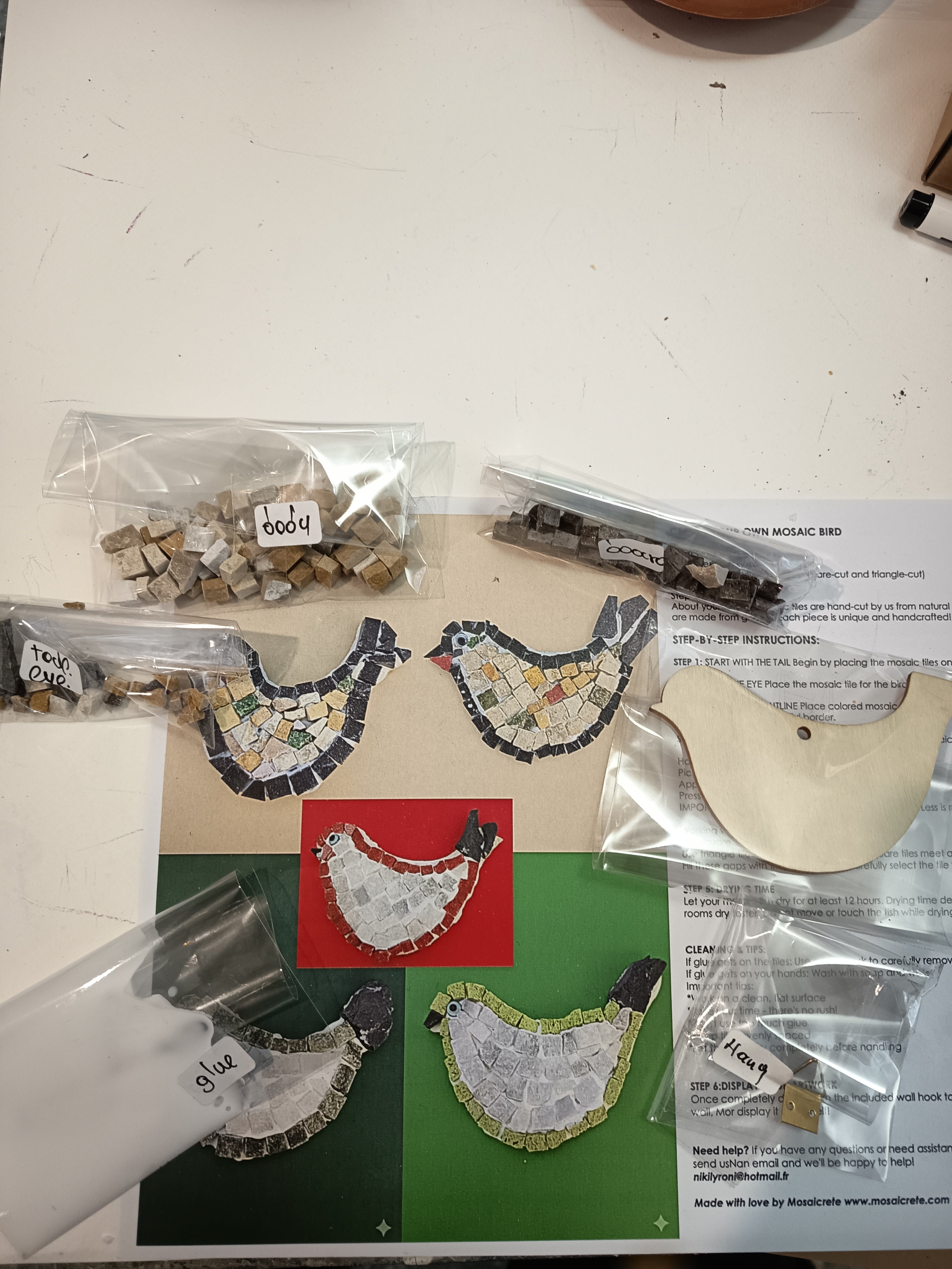 DIY mosaic bird kit contents - square tiles, triangle tiles, eye piece, border tiles, wooden base and instructions